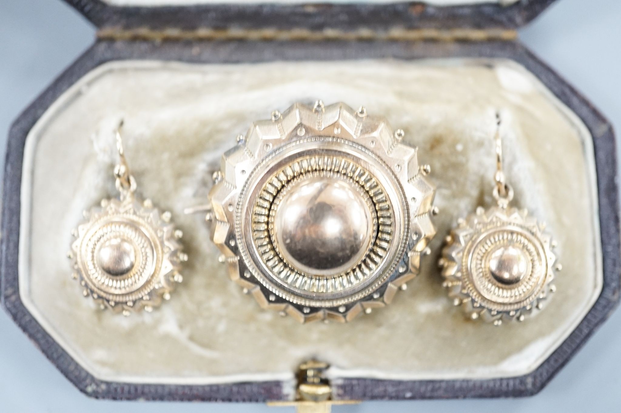 A Victorian yellow metal suite of jewellery, comprising a brooch and pair of earrings, brooch 34mm, gross 11.6 grams.